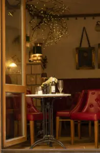 Bild des Monats September 2026 - Der Blick durch die geöffnete Tür führt in eine stilvoll eingerichtete Kaffeebar